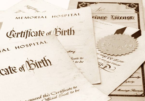 Close-up of a stack of important family papers including birth certificates and marriage license